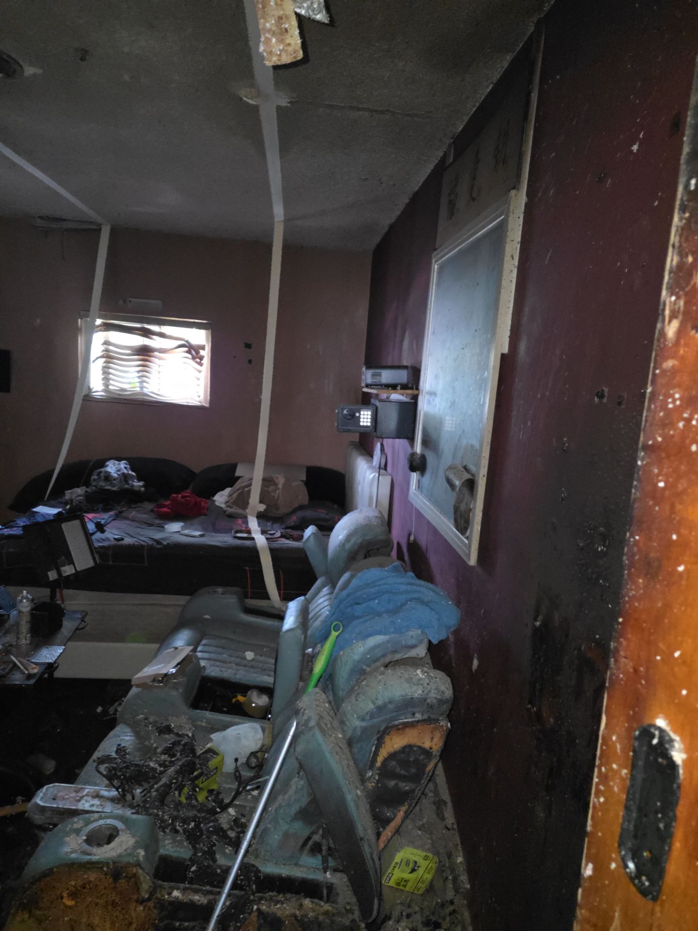 Fire-damaged bedroom with smoke-stained walls and debris